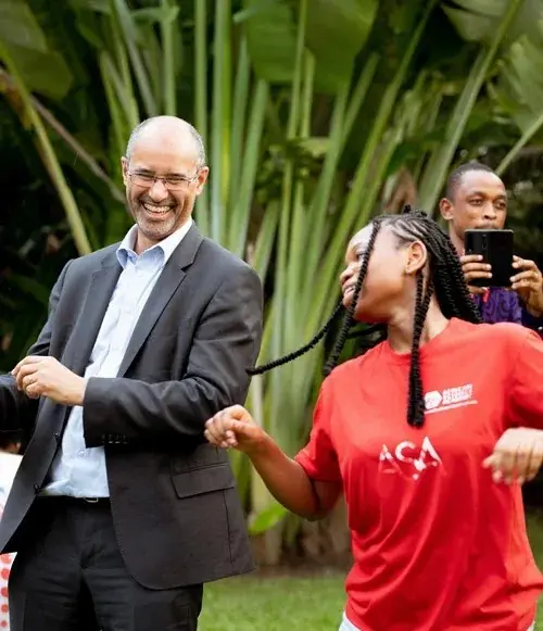 ASA founder Tom Ilube dancing with a student at a school event