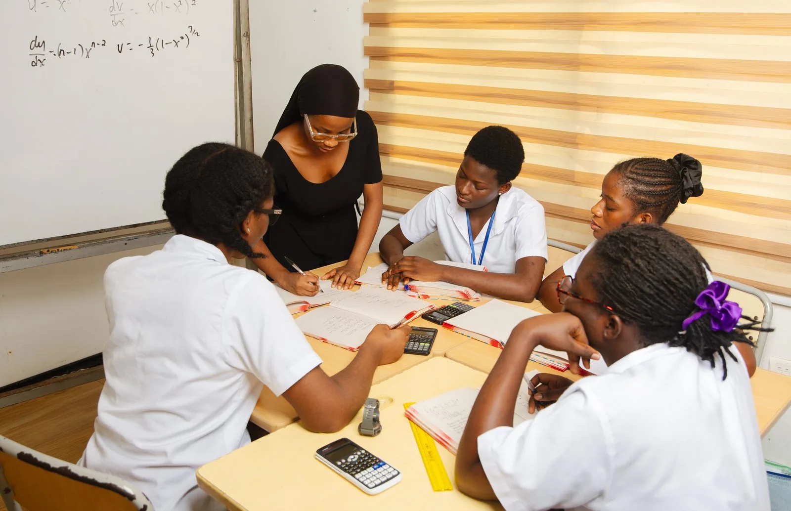 ASA students collaborating on maths problems at a whiteboard