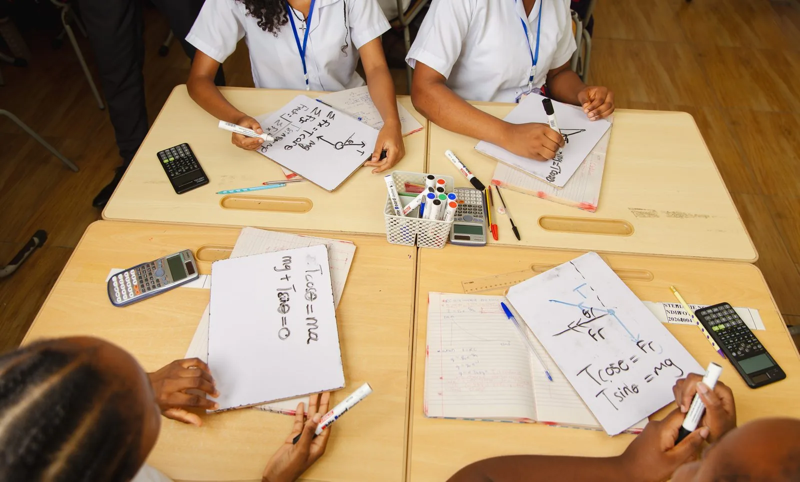 ASA students writing physics equations on mini whiteboards